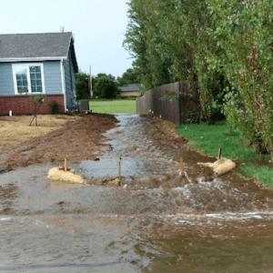 Water draining between a residential home and privacy fence