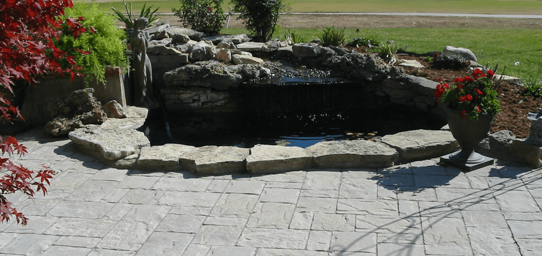 Stone water feature surrounding by a stone patio