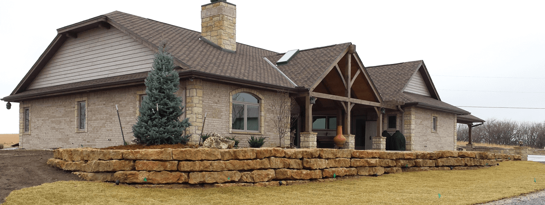 Limestone retaining wall surrounding a stone home